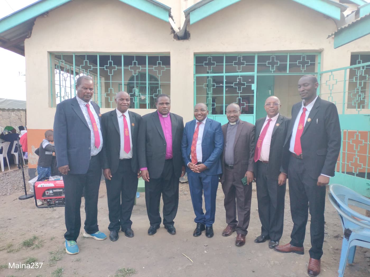 Maina with clergy at a church function in Thika